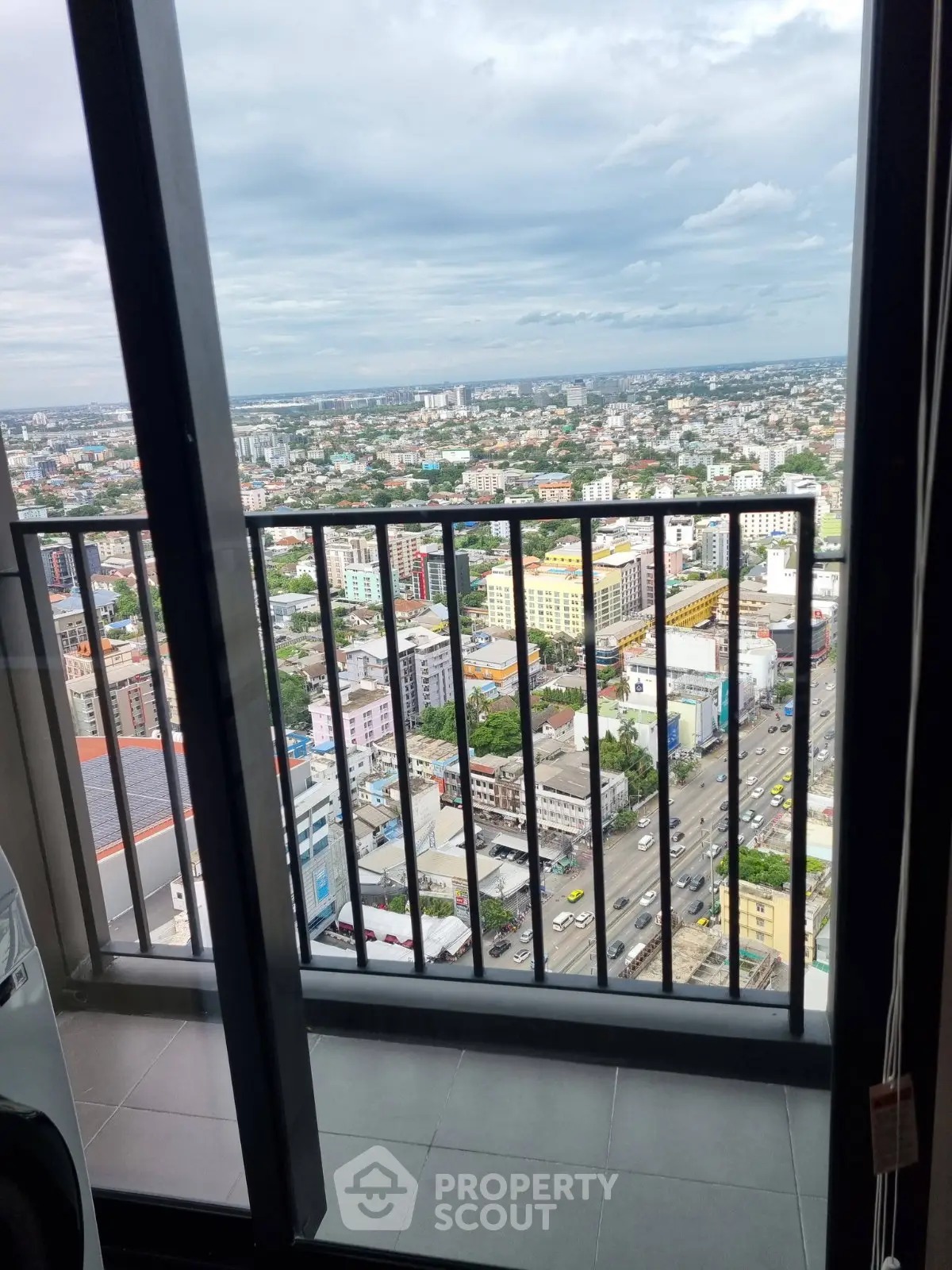 Stunning high-rise balcony view overlooking vibrant cityscape and bustling streets.