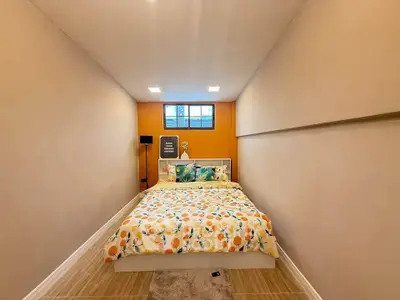 Cozy bedroom with vibrant bedding and modern decor in a compact space.