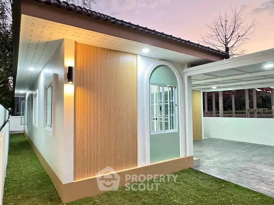 Modern single-story home with stylish exterior lighting and spacious carport at sunset.