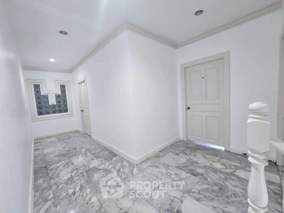 Elegant hallway with marble flooring and white doors in modern building