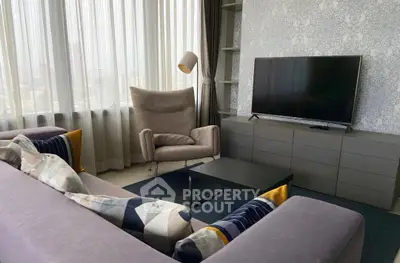 Modern living room with stylish furniture and large TV, perfect for relaxation and entertainment.