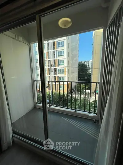 Modern apartment balcony with sliding glass doors and city view