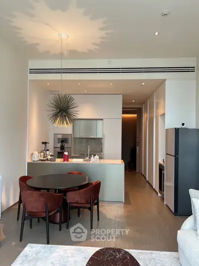 Modern open-layout kitchen with stylish dining area and contemporary lighting