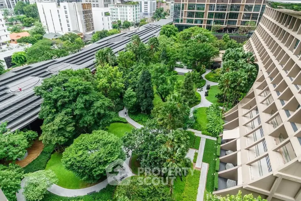 Luxurious urban garden view from high-rise building with lush greenery and modern architecture.