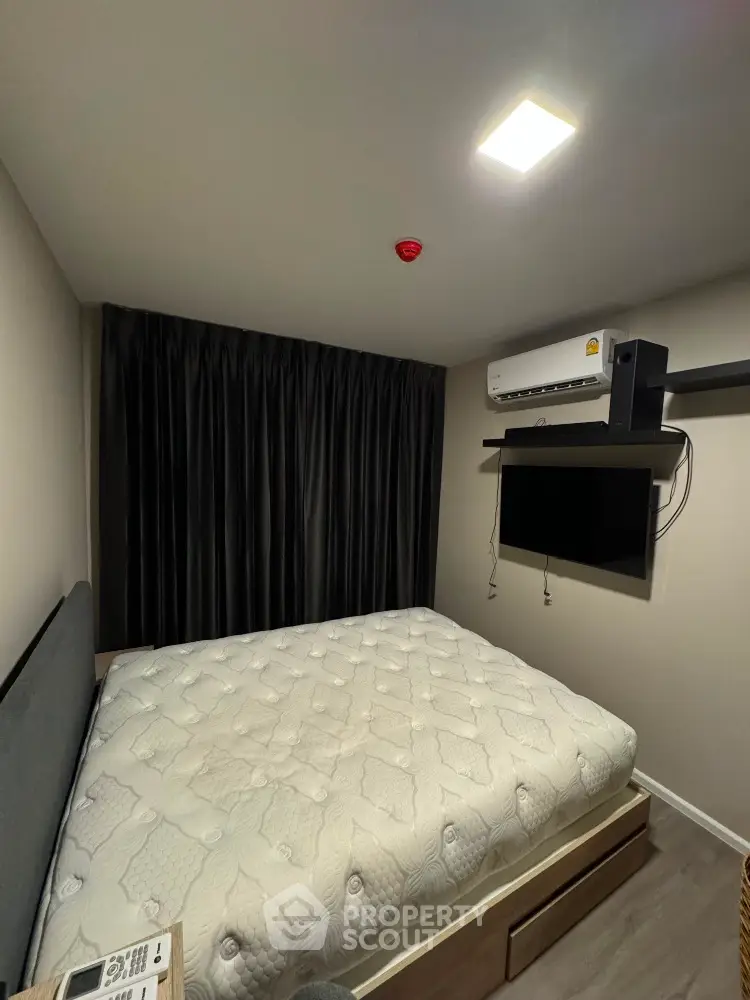 Modern bedroom with sleek design, featuring a comfortable bed and wall-mounted TV for ultimate relaxation.