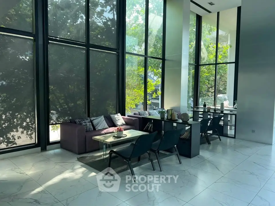 Modern living room with floor-to-ceiling windows and stylish furniture