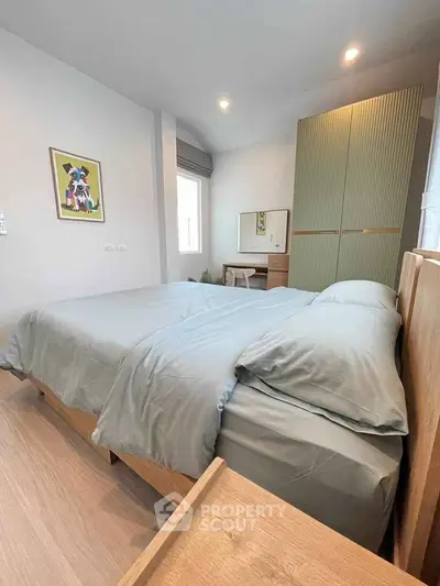 Modern bedroom with stylish decor and ample natural light, featuring a cozy bed and sleek wardrobe.
