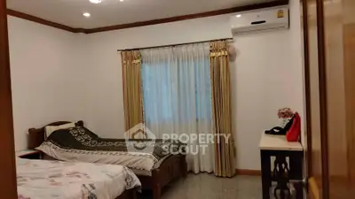 Cozy bedroom with twin beds and air conditioning, perfect for comfort and relaxation.