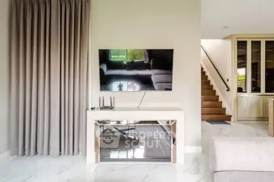 Modern living room with sleek TV setup and elegant staircase, perfect for stylish urban living.