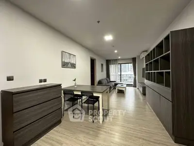 Spacious modern living room with sleek furniture and large windows offering city views.