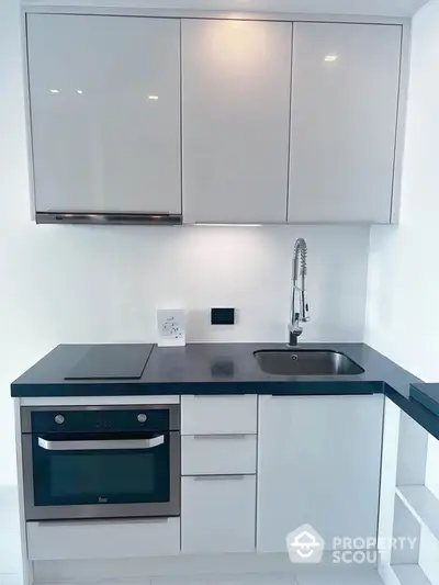 Modern kitchen with sleek cabinetry and built-in oven, ideal for contemporary living.