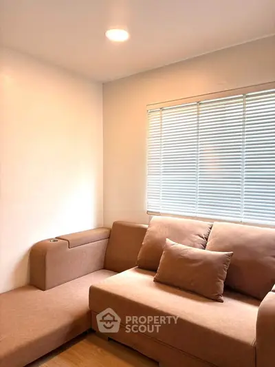 Cozy living room with modern sofa and natural light through blinds