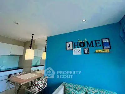 Modern living room with vibrant blue accent wall and stylish dining area.