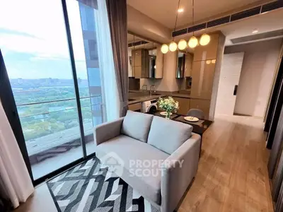 Modern living room with open kitchen and stunning city view from balcony.