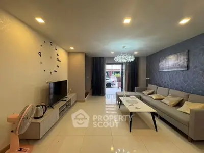 Spacious modern living room with elegant decor and large windows opening to a balcony.