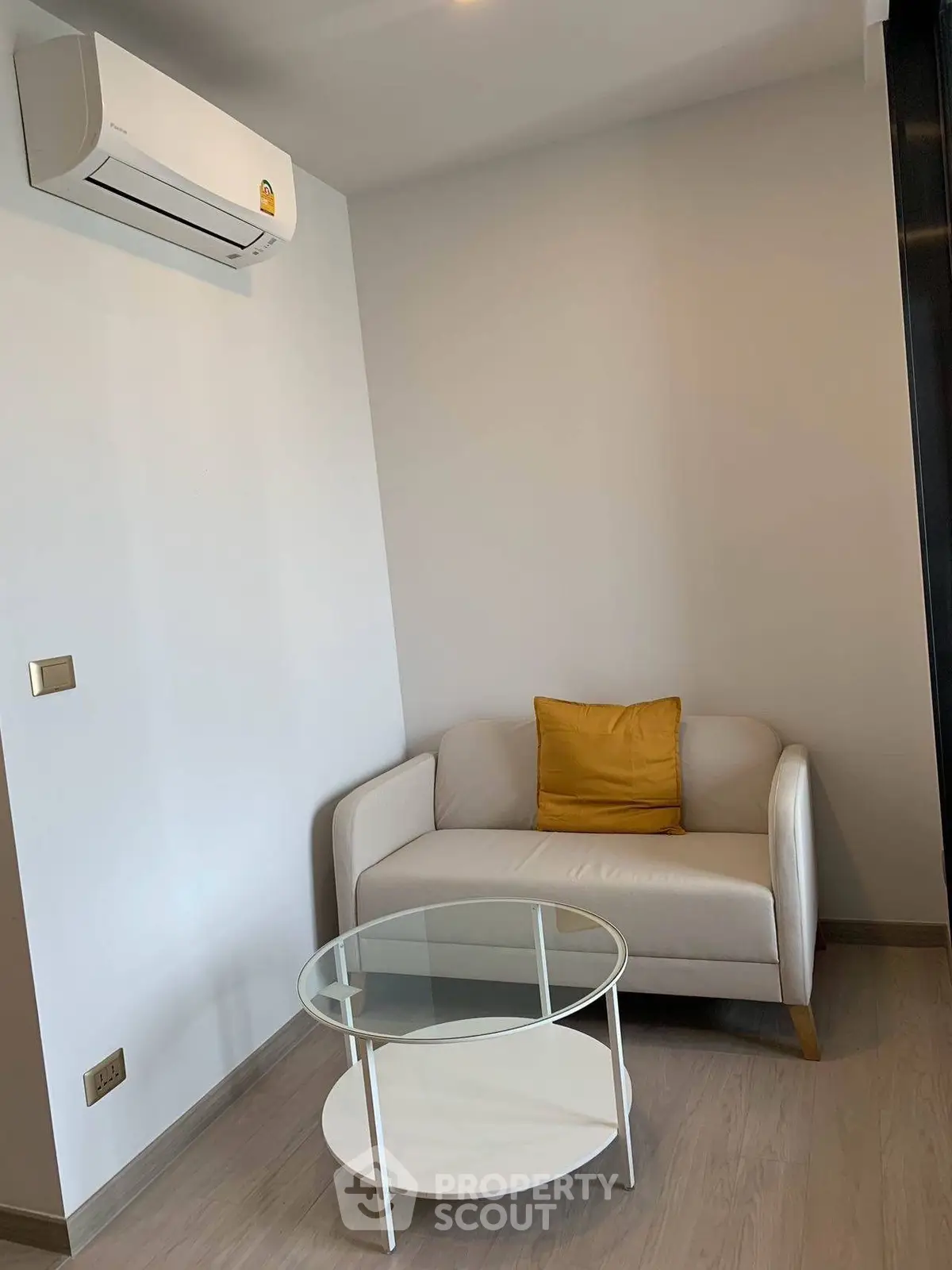 Cozy living room with modern sofa and air conditioning, perfect for relaxation.