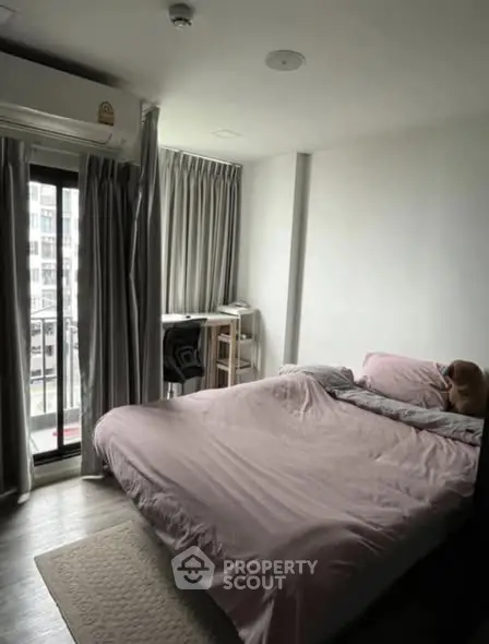 Cozy bedroom with large window and balcony access in modern apartment