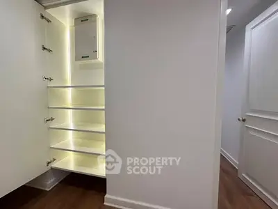 Spacious storage closet with built-in shelves and modern lighting in a contemporary home.