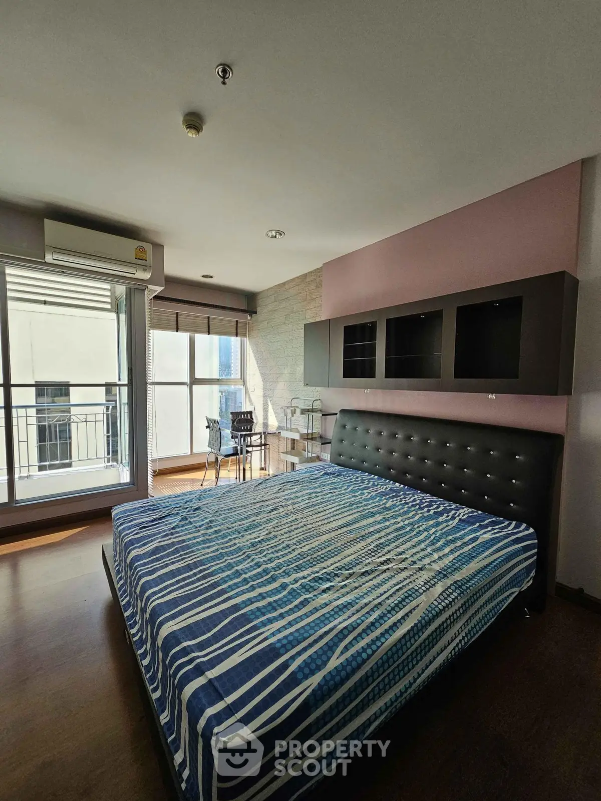 Spacious bedroom with modern decor and balcony access in a stylish apartment.