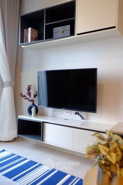 Modern living room with wall-mounted TV and stylish shelving unit