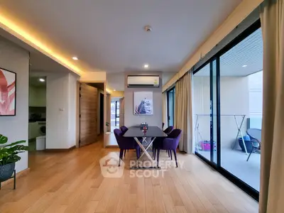 Modern living room with dining area and balcony access in stylish apartment.