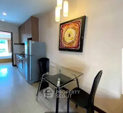 Modern kitchen with sleek appliances and stylish dining area, perfect for contemporary living.