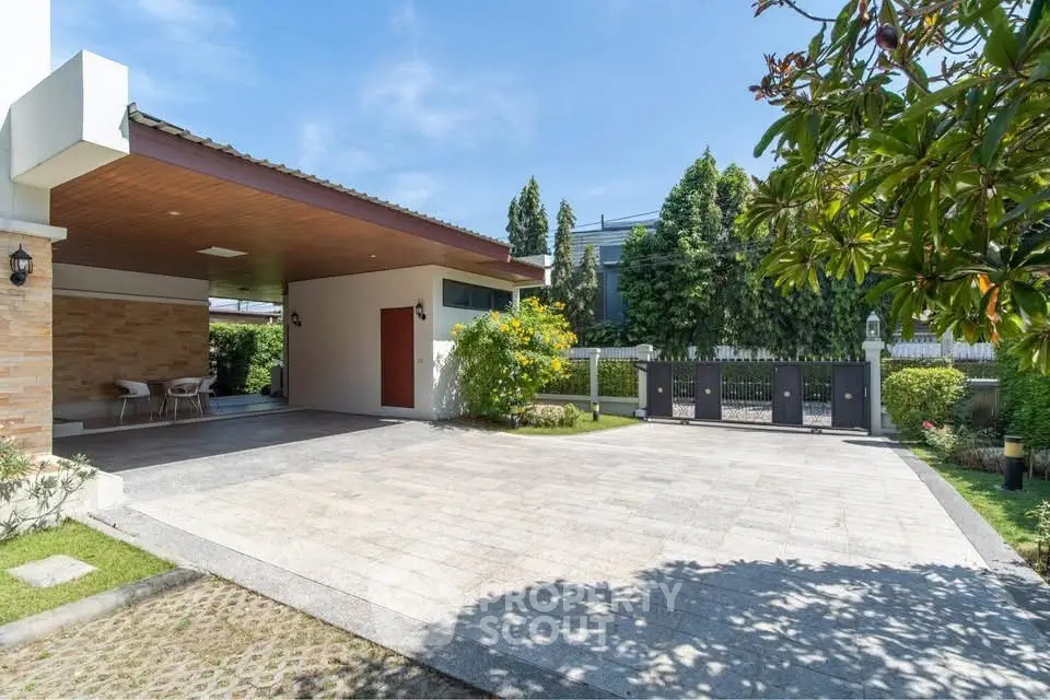 Spacious modern driveway with lush greenery and elegant entrance in a luxury home setting.