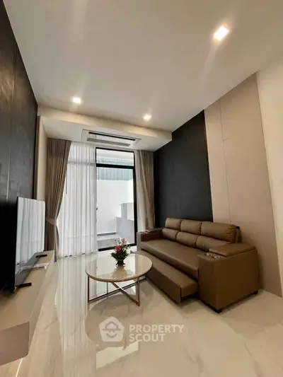 Modern living room with sleek design and large windows for natural light.