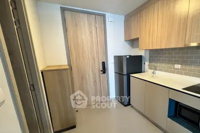 Modern kitchen with sleek cabinetry and compact appliances in a stylish apartment.