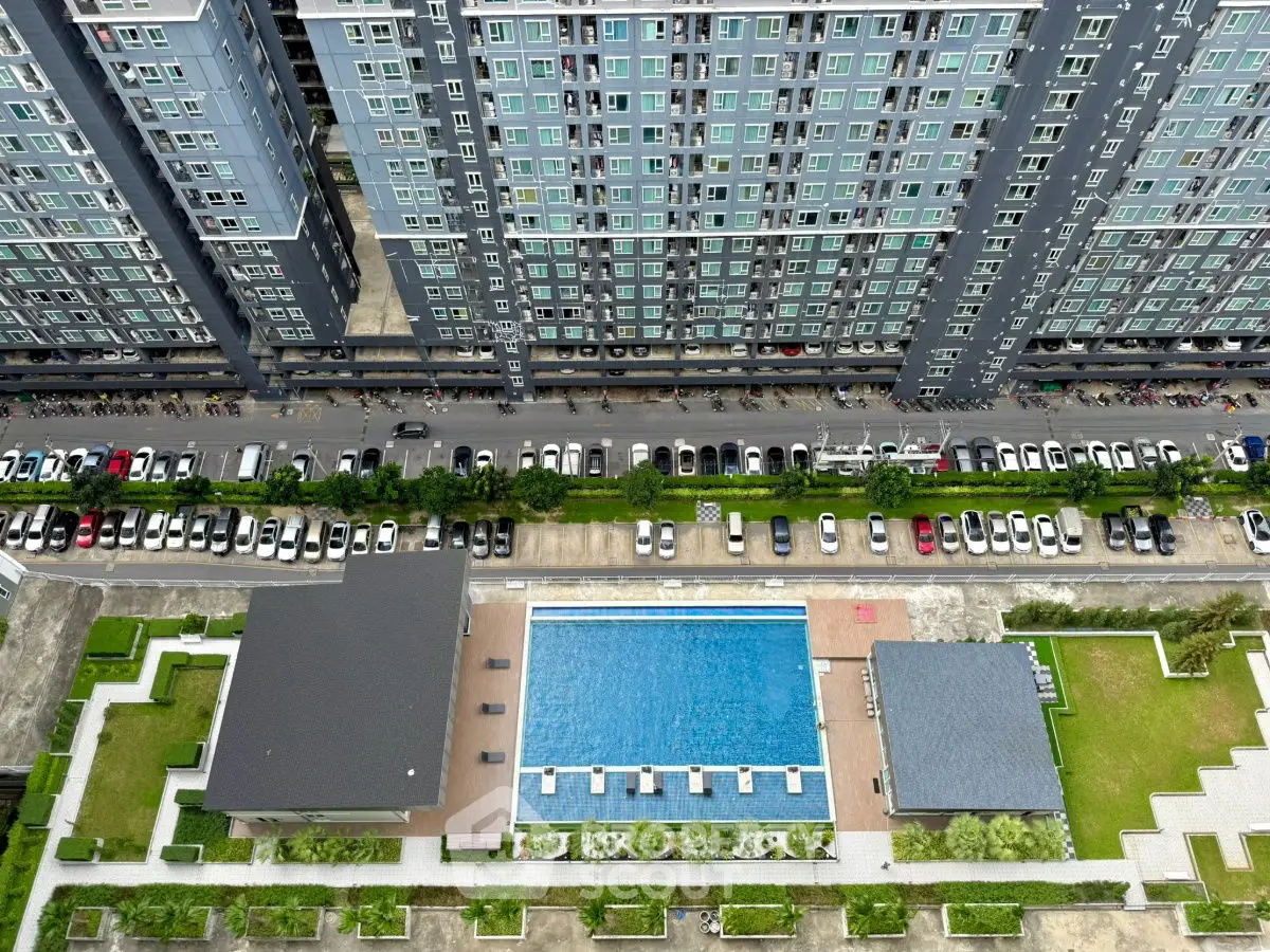 Aerial view of modern apartment complex with pool and parking