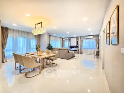 Spacious modern living room with elegant dining area and luxurious chandelier.
