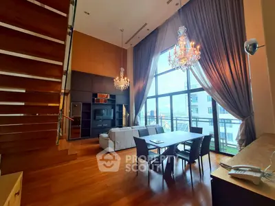 Luxurious high-ceiling living room with chandeliers and large windows offering stunning city views.