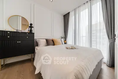 Elegant bedroom with modern decor and large windows offering city views