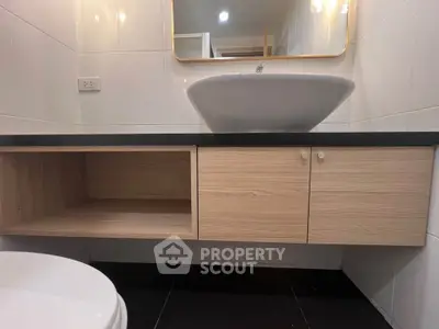 Modern bathroom with sleek vanity and stylish basin in contemporary apartment.