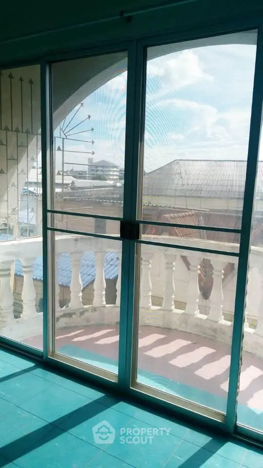 Spacious balcony with sliding glass doors and scenic view of waterfront and sky.