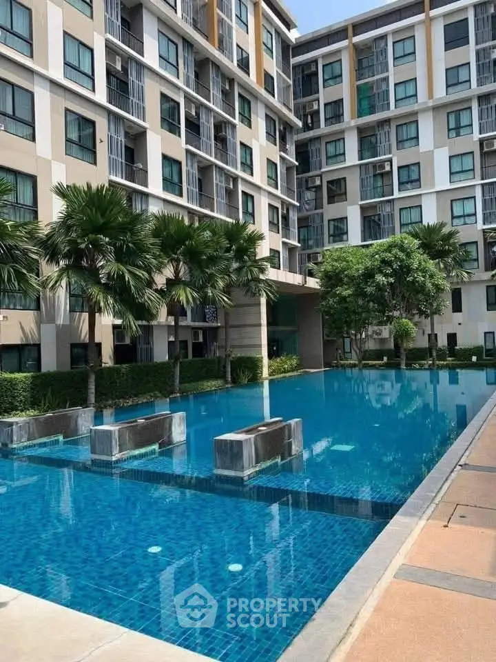 Modern apartment complex with a stunning outdoor pool and lush greenery.