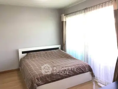 Bright bedroom with large window and modern bed in a cozy apartment