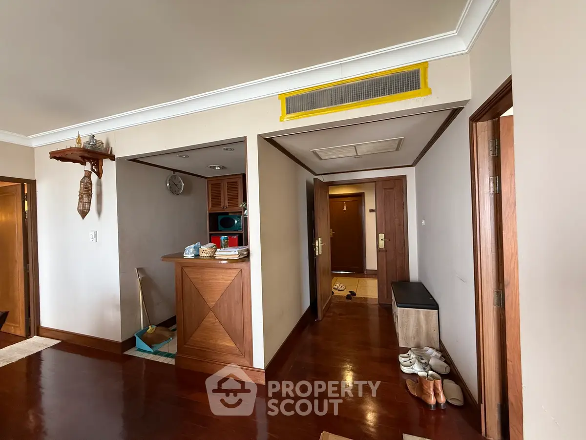 Spacious entryway with wooden flooring and modern decor in a stylish apartment.