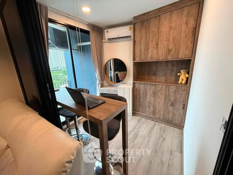 Modern study room with wooden cabinetry and balcony view
