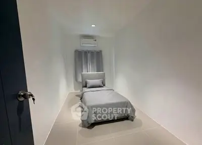 Minimalist bedroom with single bed and air conditioning in modern apartment.