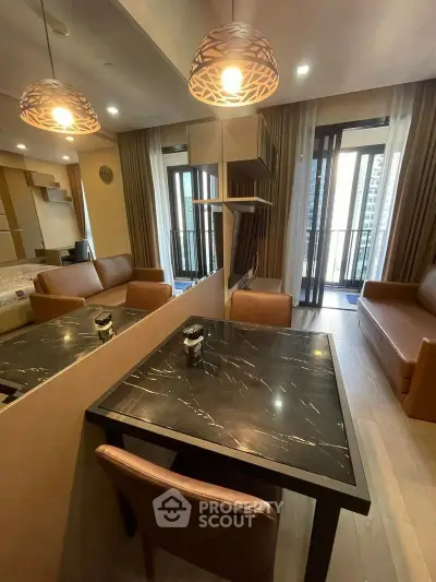 Modern living room with stylish furniture and balcony view in a high-rise apartment.