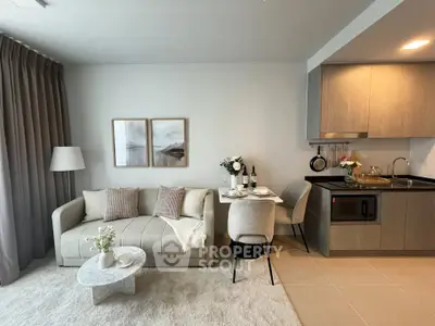 Modern living room with cozy sofa, dining area, and stylish kitchen in open layout apartment.