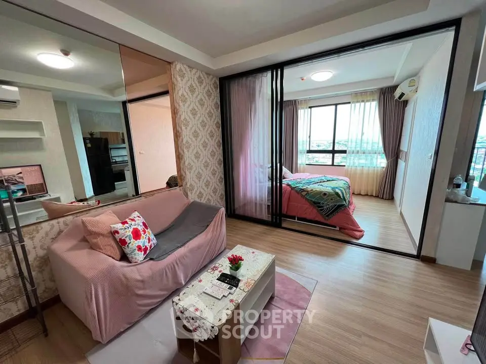 Modern apartment with open living room and bedroom, featuring stylish decor and large windows for natural light.