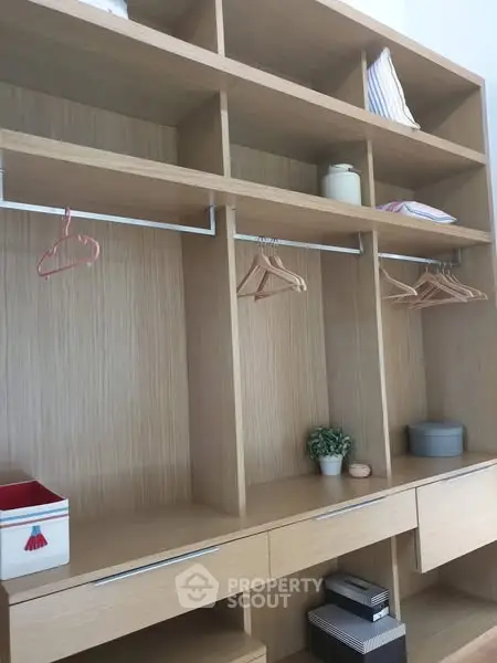 Spacious wooden storage unit with shelves and hangers, perfect for organizing.
