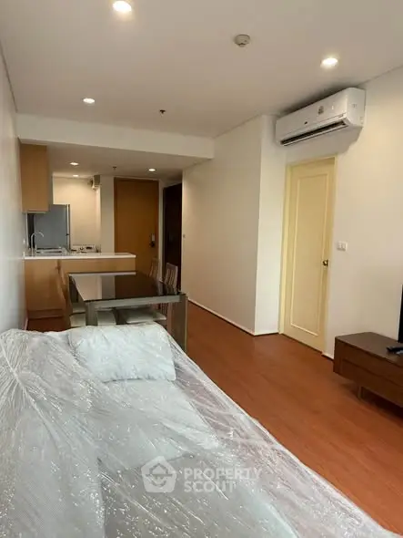 Modern living room with open kitchen layout and air conditioning in a cozy apartment.
