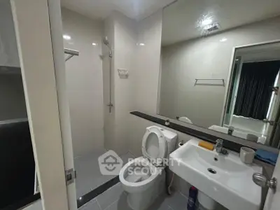 Modern bathroom with sleek fixtures and large mirror in a contemporary apartment.