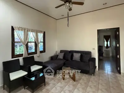 Cozy living room with modern furniture and ceiling fan, perfect for relaxation.
