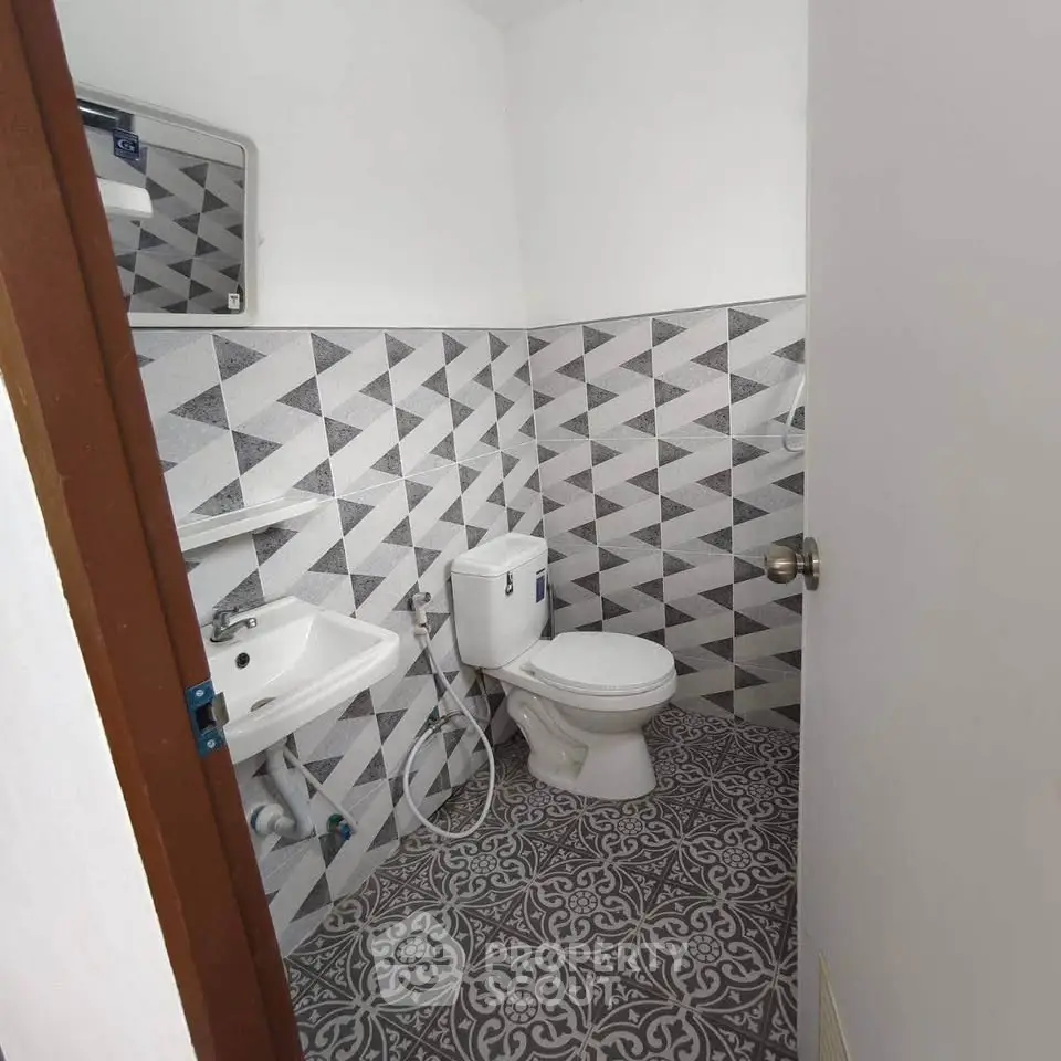 Modern bathroom with geometric tiles and compact design