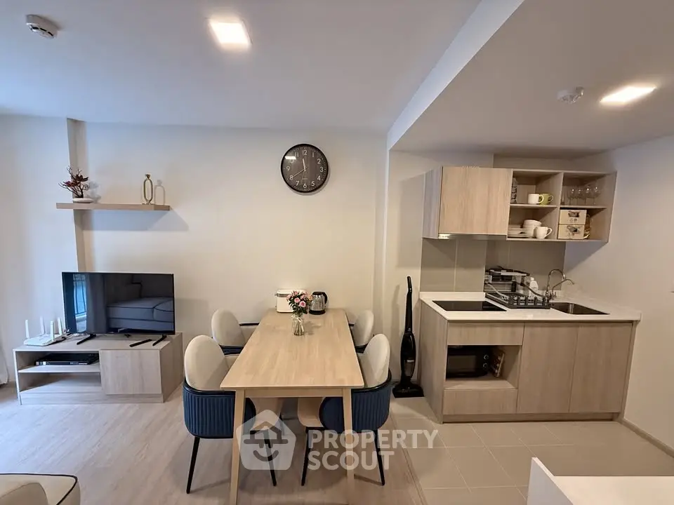 Modern open-plan living room and kitchen with stylish decor and dining area.