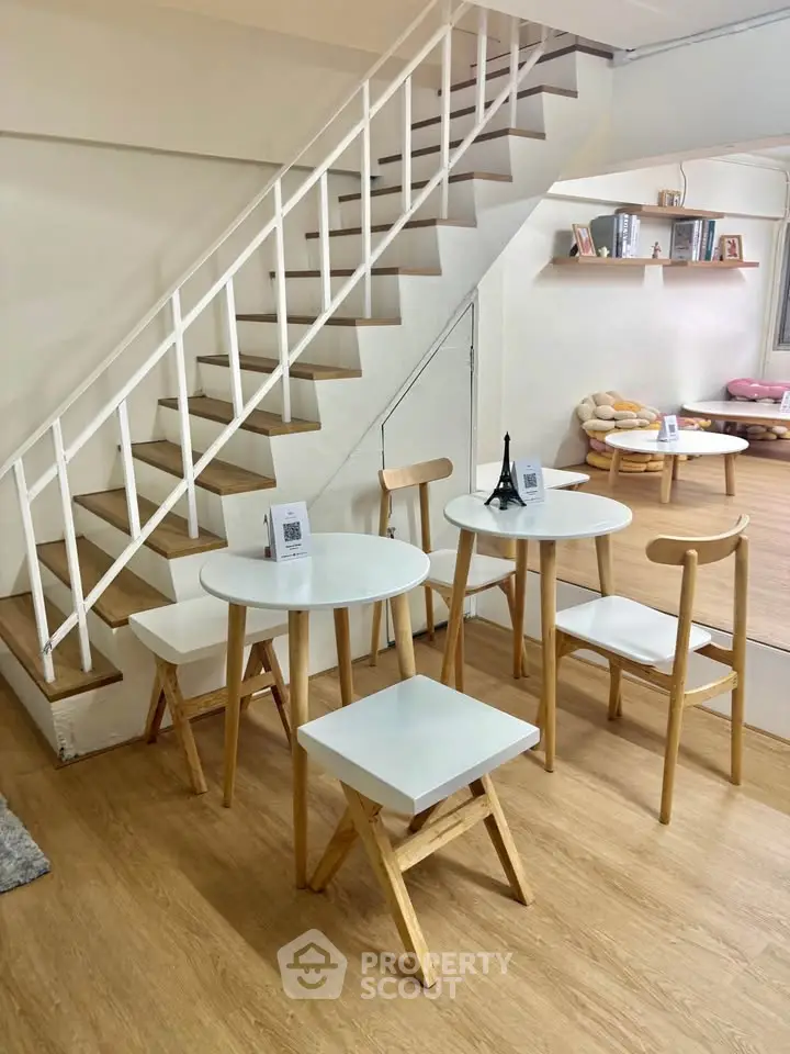 Charming interior with modern staircase and cozy seating area, perfect for relaxation and gatherings.